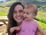 Aline Favaro com a filha, sorrindo ao ar livre